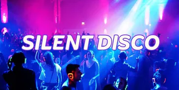 An image of people dancing in a nightclub during a silent disco wearing headphones.